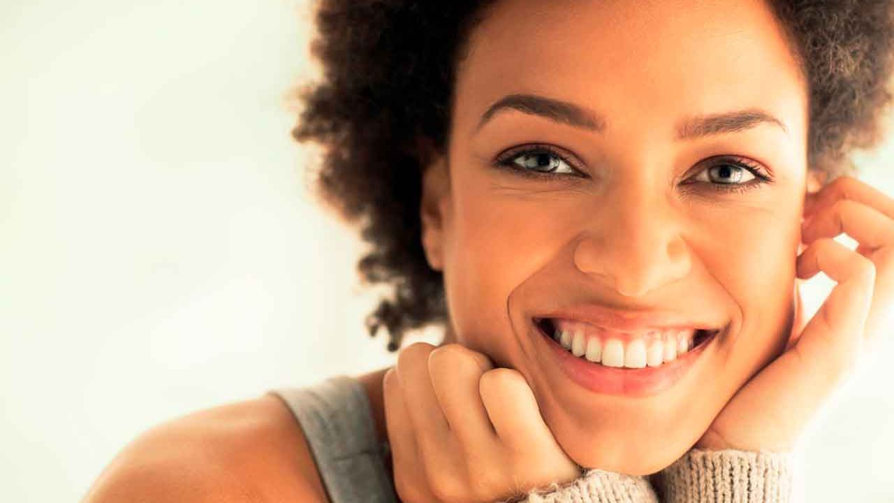 uma pessoa sorrindo, representando a sensação de frescor e confiança proporcionada pelos enxaguantes bucais sem álcool.